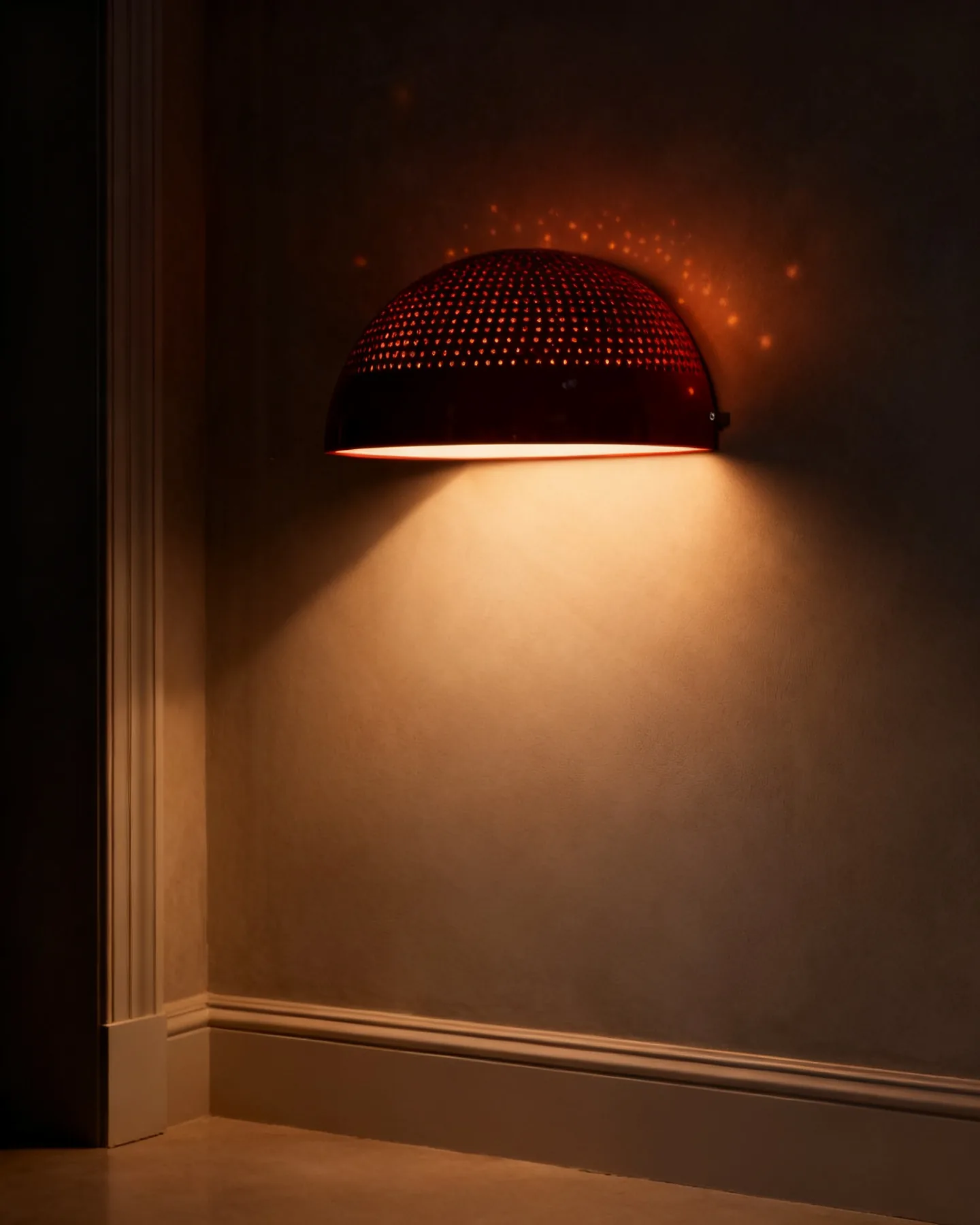 A perforated dome shade with a field of pinpricks of warm light