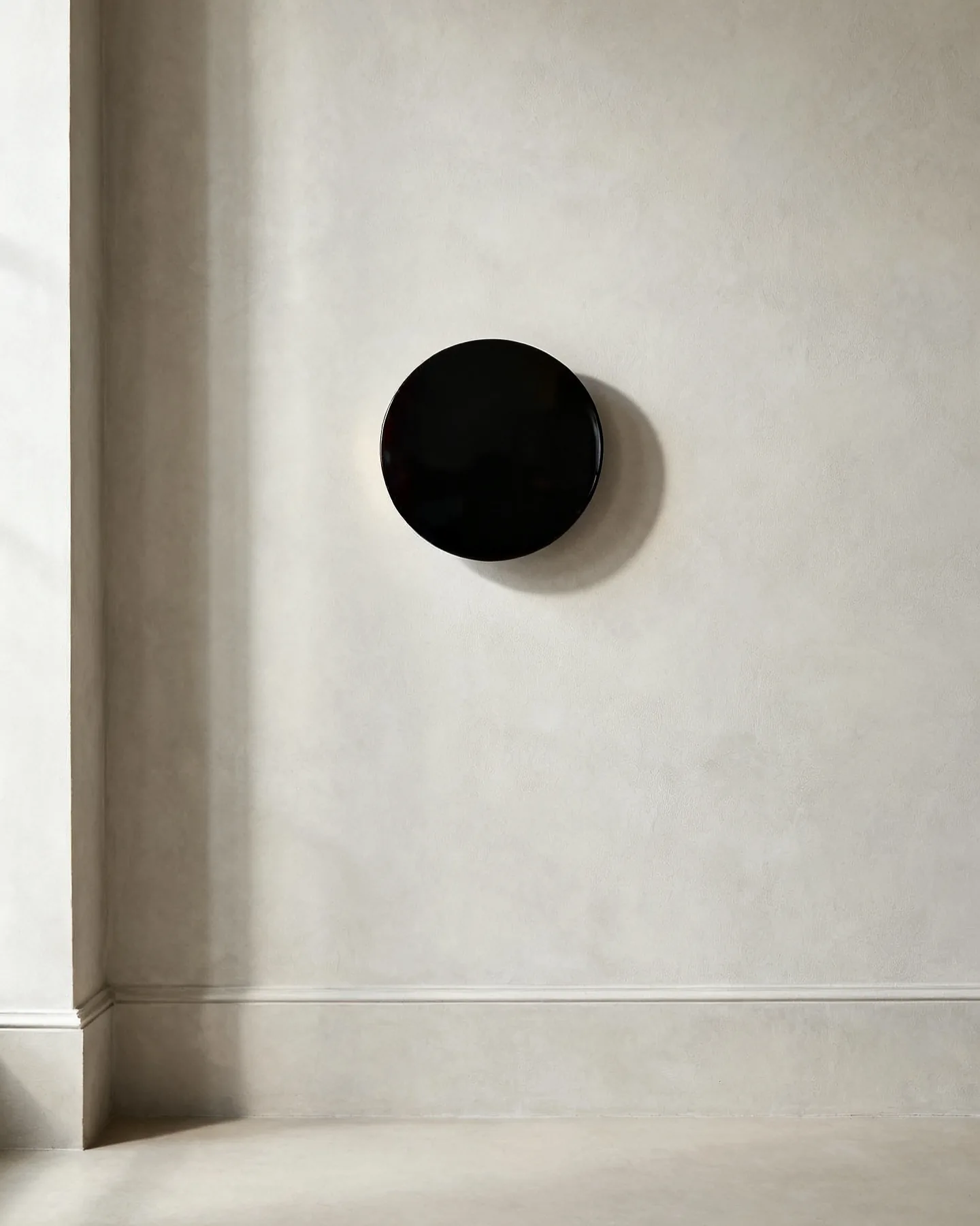 The Escutcheon in black cherry, wall-mounted in daylight with the light switched off