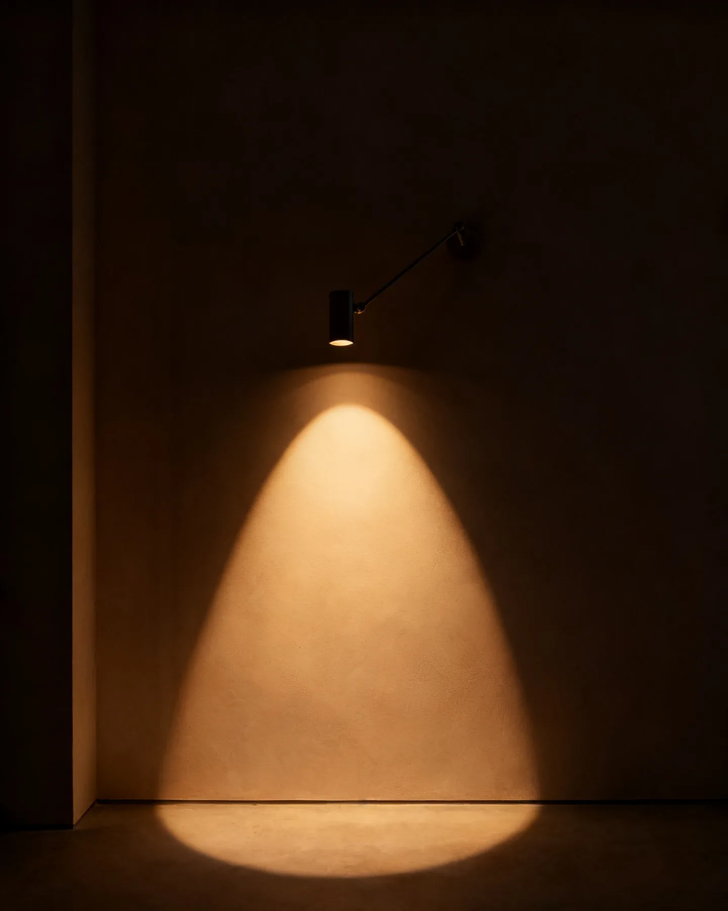 An articulated arm light laying a defined cone of light on a wall